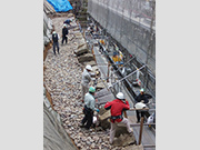 修復中の石垣と使用する白河石（加工前）